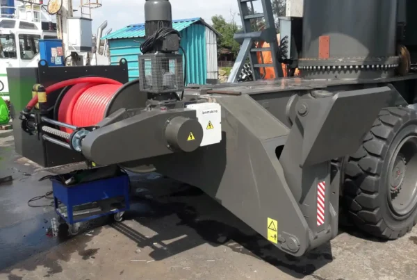 BM Makina KATO MKT Geniş Sarım Kablo Toplama Tamburu, liman tipi lastik tekerlekli mobil vinç üzerinde yandan görünüm, kırmızı güç kablosu sarılı halde.